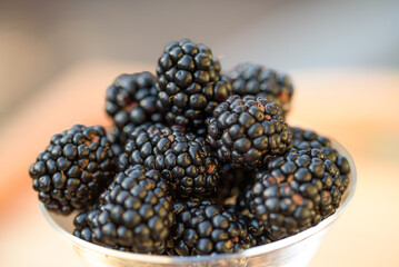 Fresh sweet blackberry in glass on a wooden table, rustic background, selective focus