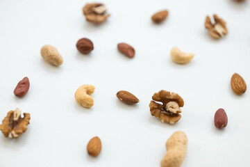 Fototapeta na wymiar Pattern of nuts mix. Cashew, peanut, hazelnuts, walnuts, almonds on white background