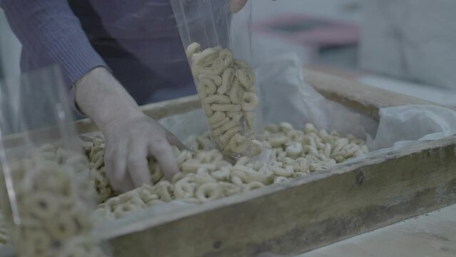 uomo in fabbrica che mette i taralli in busta