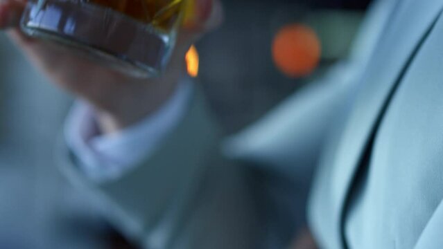 Businessman hands drinking whiskey in office closeup. Burbon glass concept