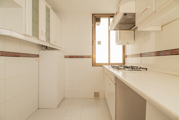 Fototapeta na wymiar Kitchen with white furniture and details in red, countertop and appliances in the same color and border on the tiles, cabinet with glass cabinet and golden aluminum window