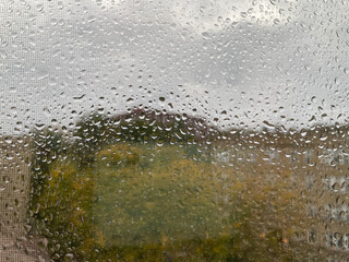 Closeup - heavy rain drops on the window and screen during hurricane 