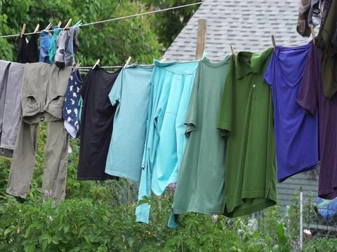 clothes hanging on a clothesline being blown by the wind close up in backyard