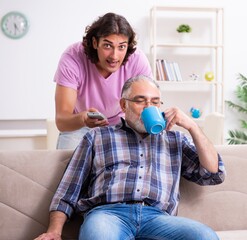 Young student and his old grandpa at home