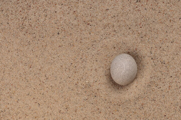 Fototapeta na wymiar White stone on sand for relaxation balance and harmony spirituality or wellness spa. Top view.