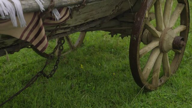 Film shot. Historian Old wooden cart wheel at sand beach