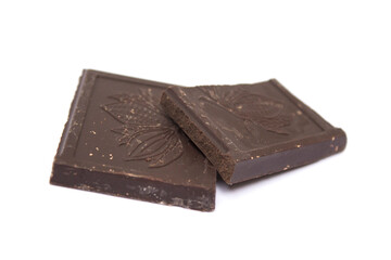 two cubes of dark chocolate lie on a white background