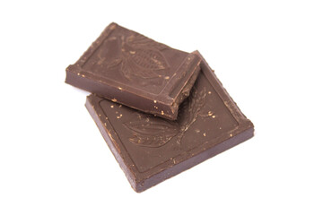 two cubes of dark chocolate lie on a white background