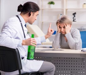 Fototapeta premium Female alcoholic visiting young male doctor