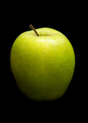 green apple lies on a black background