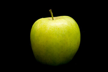 green apple lies on a black background
