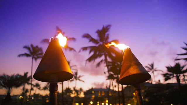 Hawaii sunset with fire torches. Hawaiian icon, lights burning at dusk at beach resort or restaurants for outdoor lighting and decoration. Cozy atmosphere, dream trip, tropical island, summer vacation
