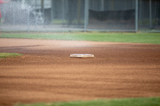Infield groomer spraying water on the baseball field 