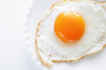 Homemade comfort food, sunny side up fried egg on white plate