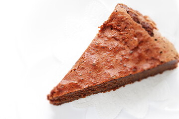 Piece of homemade chocolate cake on white dish with mint