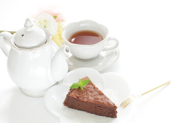 Piece of homemade chocolate cake on white dish with mint