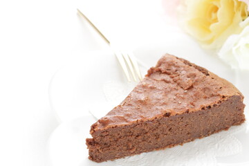 Piece of homemade chocolate cake on white dish with mint