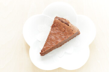 Piece of homemade chocolate cake on white dish with mint