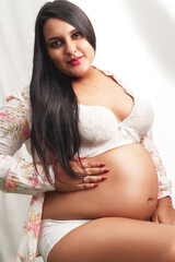 Beautiful pregnant woman on lingeries posing 