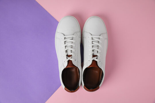 Pair of stylish white sneakers on color background, flat lay