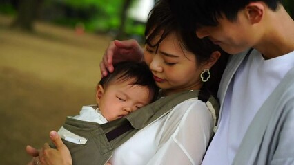 眠る子供を見つめる親