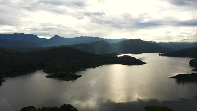Top view of lake among green hills and mountains early in the morning. Tropical landscape. Victoria Reservoir, Sri Lanka.