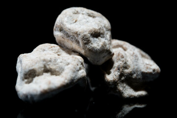 selective focus Salty Chinese plums with dark background and lighting. look like stone or rock.
