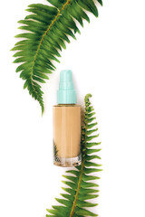 Makeup foundation with fern leaves on white background
