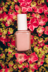 Nail polish mockup bottle liying on hydrangea flowers, top view