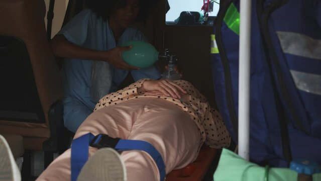 Professional nurse or doctor helping a patient about respiratory with oxygen mask on ambulance before to hospital, first aid and resuscitation, emergency and assistant, medical and insurance concept.