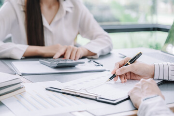 Marketer or analytic manager team dressed in suits working with paper charts and laptops at the meeting room.