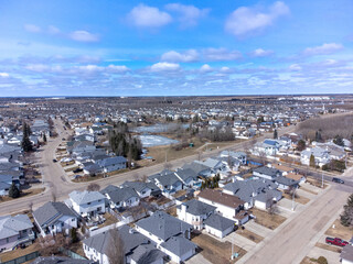 Drone aerial shot real estate, houses in row blue sky.  Neighbourhood.  View flat prairies in Canada