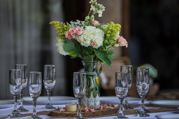Beautiful bridal bouquet of fresh flowers and wine glasses 