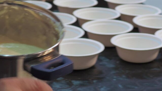 Hands serving mashed potatoes on cardboard tasting cups. Gimbal, close up