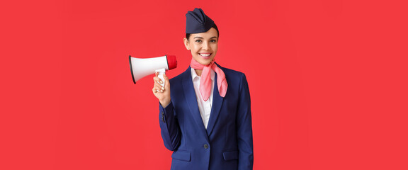 Beautiful stewardess with megaphone on red background