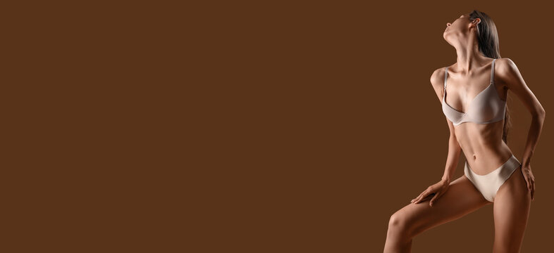 Young skinny woman in underwear on brown background with space for text. Anorexia concept