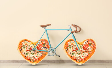 Modern bicycle with heart shaped pizza instead of wheels near light wall