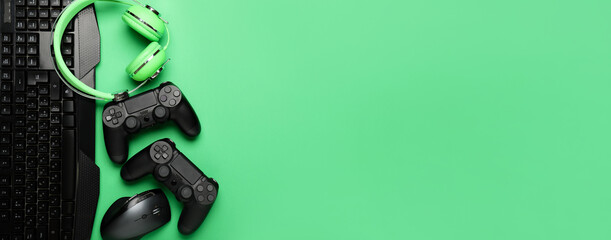 Modern gaming accessories on green background with space for text