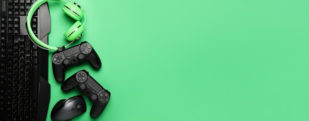 Modern gaming accessories on green background with space for text © Pixel-Shot