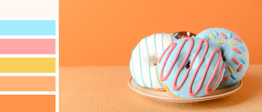 Plate with sweet donuts on orange background. Different color patterns