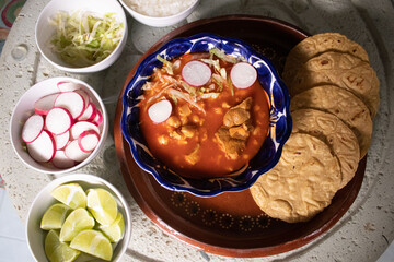 Pozole rojo con tostadas e ingredientes 