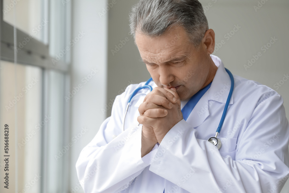 Canvas Prints praying mature male doctor in clinic