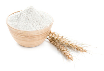 Bowl of flour and wheat ears on white background