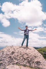 Latino student on top of a hill with arms wide open