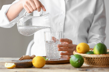 Woman pouring drink with chia seeds into glass
