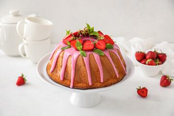Dessert stand with tasty strawberry cake on light background