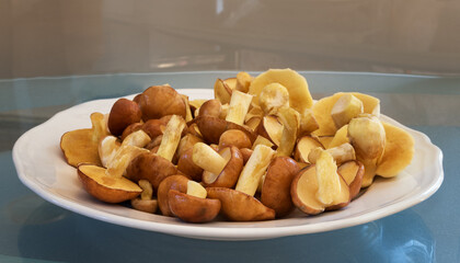 Butter mushrooms in a porcelain plate on a glass background.