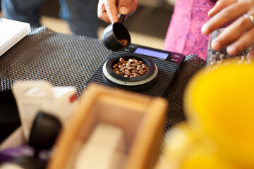 Weighing coffee beans with digital scale in coffee cafe.