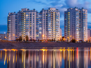 Night view of apartment block building. Residential building. Reflection in water. Cityscipe.