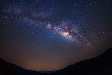Landscape milky way galaxy with stars and silhouette of a standing happy man, Long exposure...